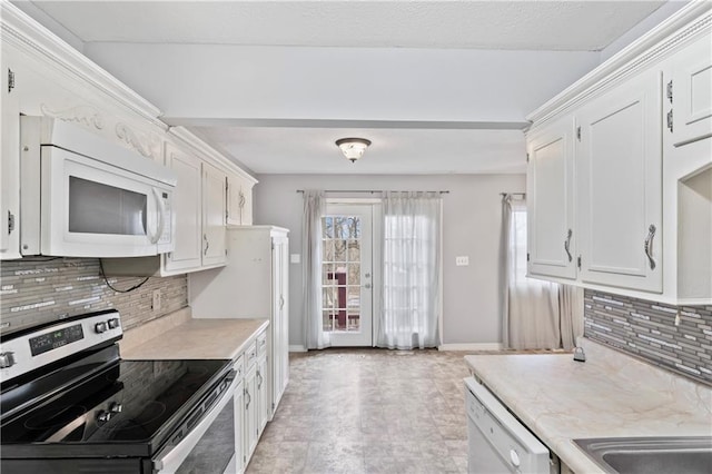 kitchen featuring light countertops, white appliances, and white cabinetry