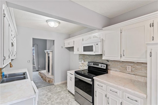 kitchen featuring white microwave, a sink, electric stove, light countertops, and tasteful backsplash