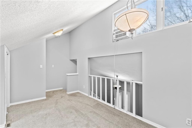 additional living space featuring carpet floors, lofted ceiling, a textured ceiling, and baseboards