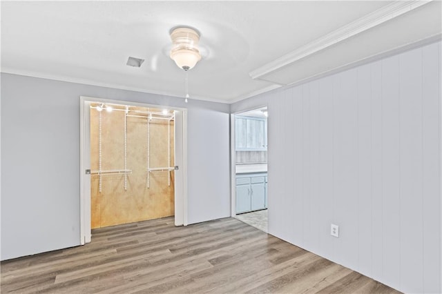 unfurnished room featuring ornamental molding and wood finished floors