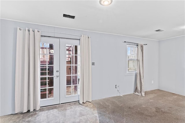 spare room with french doors, carpet, and visible vents