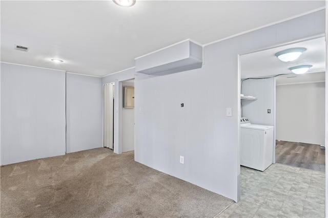 spare room with visible vents, washer and clothes dryer, and light colored carpet