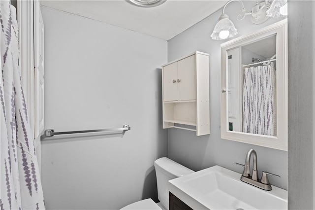 bathroom featuring curtained shower, vanity, and toilet