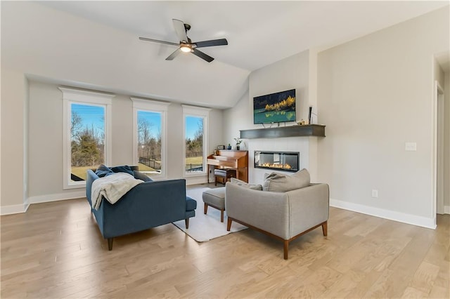 living room with lofted ceiling, ceiling fan, and light wood-type flooring