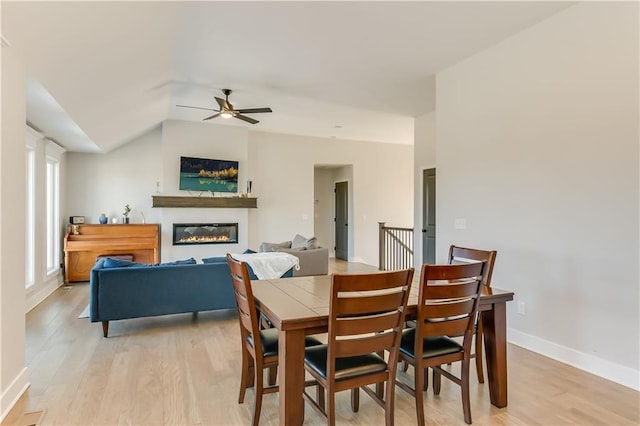 dining space featuring ceiling fan, lofted ceiling, and light hardwood / wood-style floors