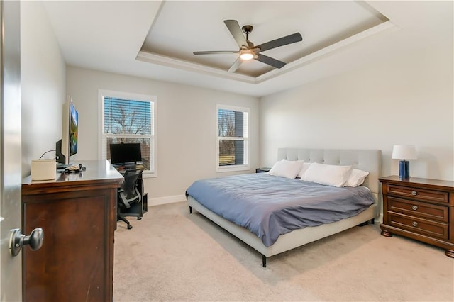 carpeted bedroom featuring a raised ceiling, ceiling fan, and multiple windows