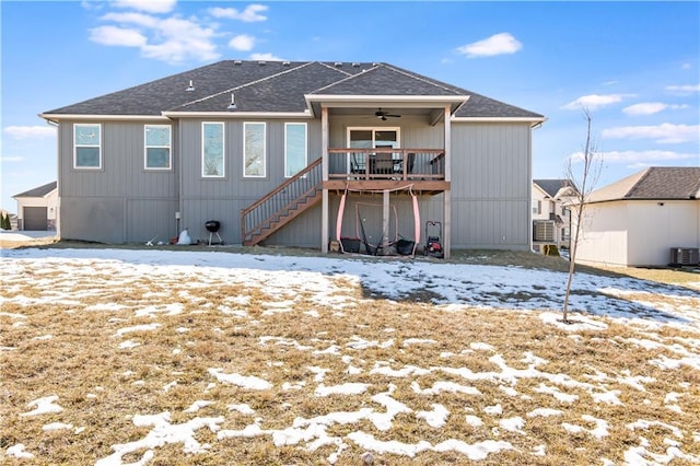 snow covered back of property with a wooden deck and ceiling fan