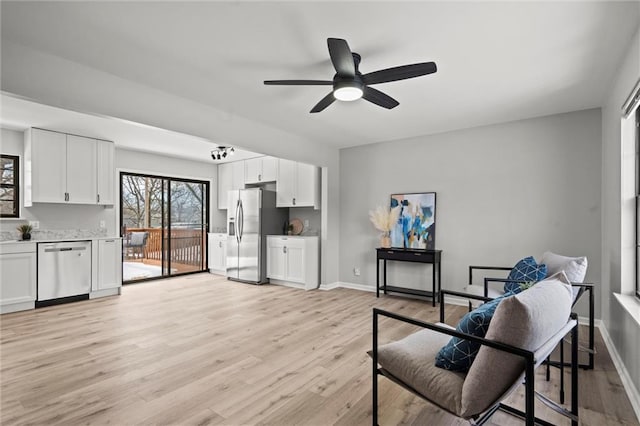 living area with light hardwood / wood-style floors and ceiling fan