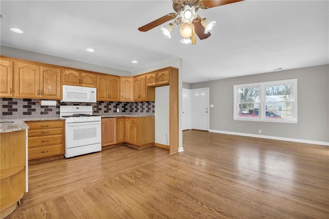 kitchen with tasteful backsplash, ceiling fan, light hardwood / wood-style floors, light stone countertops, and white appliances