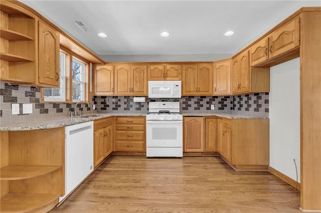 kitchen featuring sink, white appliances, light hardwood / wood-style flooring, light stone counters, and tasteful backsplash