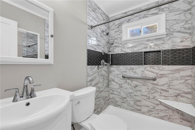 bathroom featuring sink, tiled shower, and toilet