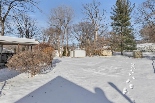 snowy yard with a storage shed