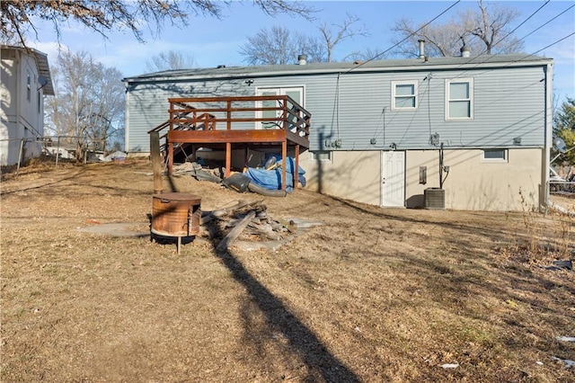 rear view of property with cooling unit, a lawn, and a deck