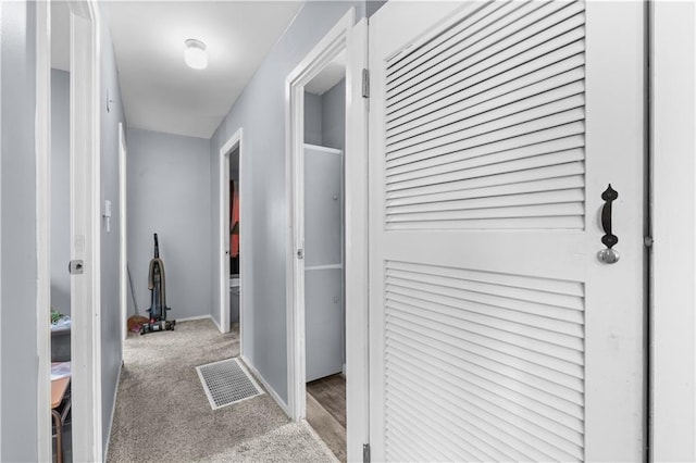 hallway featuring light colored carpet