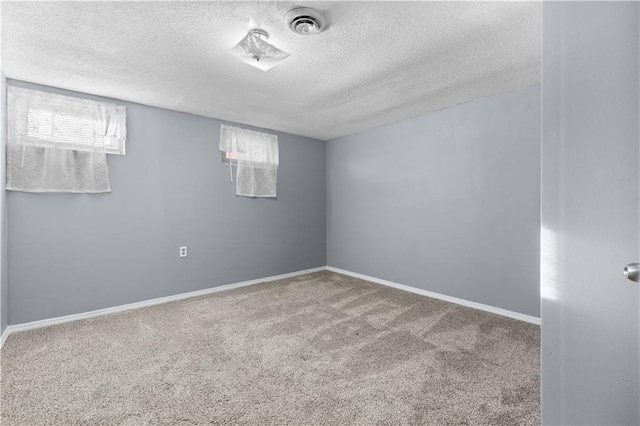 carpeted spare room featuring a healthy amount of sunlight and a textured ceiling