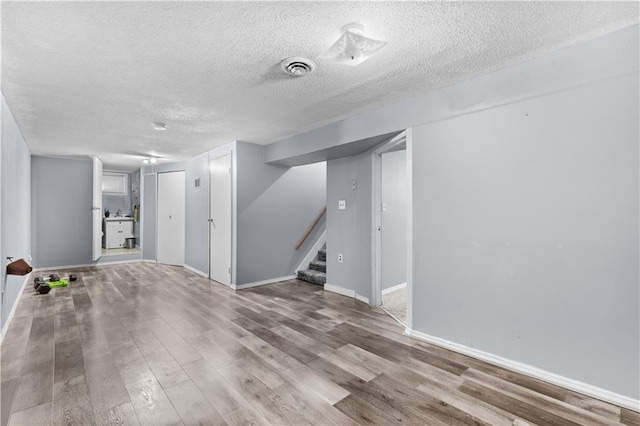 basement with wood-type flooring and a textured ceiling