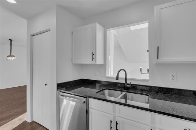 kitchen featuring white cabinetry, dark stone counters, dishwasher, and sink