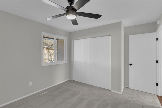 unfurnished bedroom with ceiling fan, a closet, and light carpet