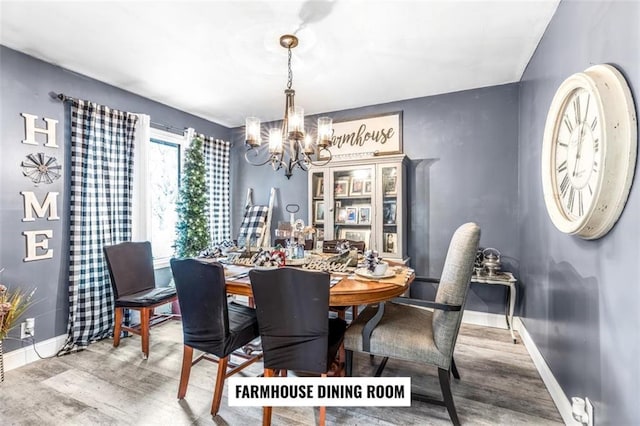 dining area with wood-type flooring and an inviting chandelier