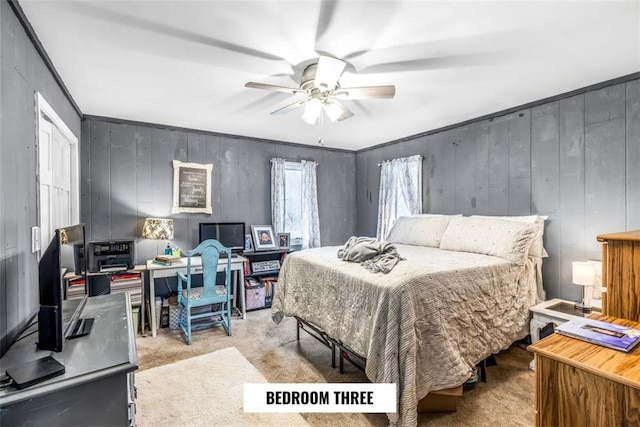 carpeted bedroom featuring crown molding and ceiling fan