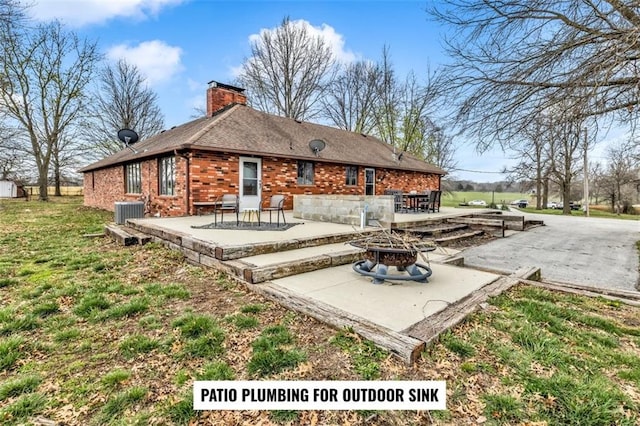 back of property featuring central AC, an outdoor fire pit, and a patio area