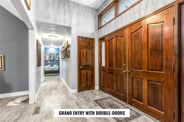 entryway with light hardwood / wood-style flooring and a high ceiling