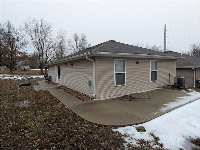 view of side of property with central AC unit and a patio area