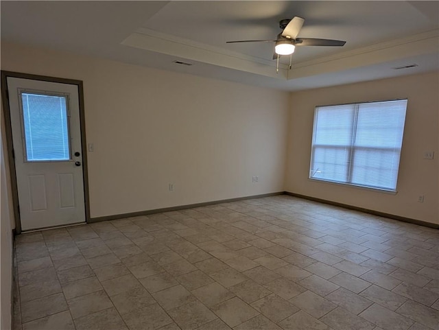 spare room featuring ceiling fan and a raised ceiling