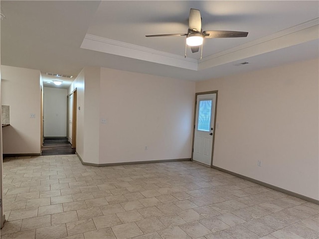 unfurnished room with a raised ceiling, ornamental molding, and ceiling fan