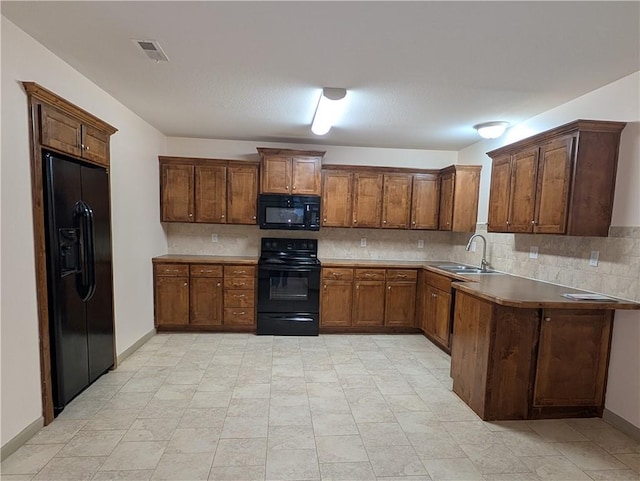 kitchen featuring sink, decorative backsplash, and black appliances