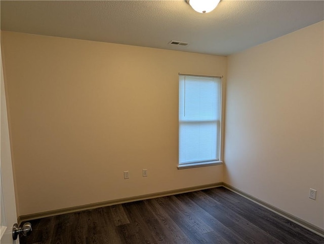 unfurnished room with dark hardwood / wood-style floors and a textured ceiling