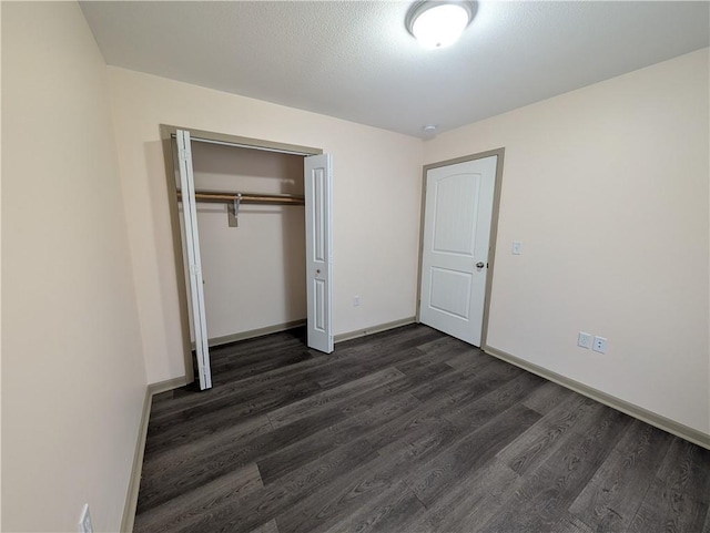 unfurnished bedroom with dark hardwood / wood-style flooring, a closet, and a textured ceiling