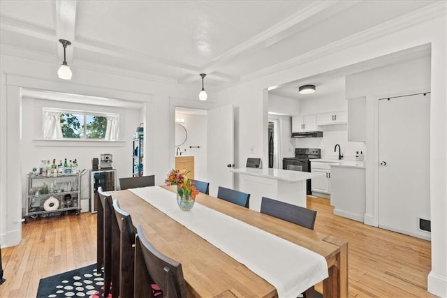 dining room with beamed ceiling, coffered ceiling, sink, and light hardwood / wood-style flooring