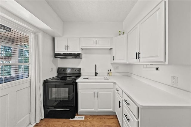 kitchen with sink, light hardwood / wood-style flooring, black range with electric stovetop, a textured ceiling, and white cabinets