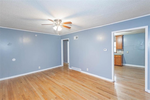 empty room featuring crown molding, light hardwood / wood-style flooring, a textured ceiling, and ceiling fan