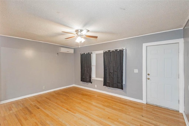 spare room featuring a wall mounted air conditioner, crown molding, hardwood / wood-style floors, and ceiling fan