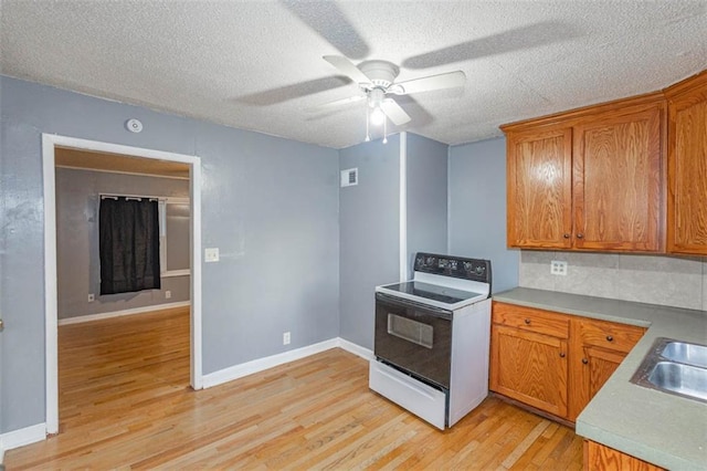 kitchen with sink, white electric range oven, ceiling fan, a textured ceiling, and light hardwood / wood-style flooring