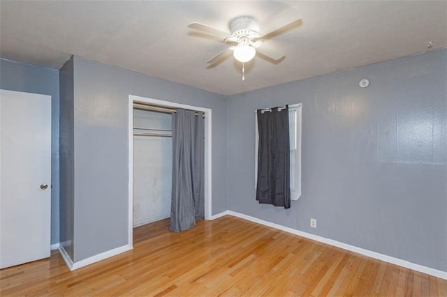 unfurnished bedroom featuring ceiling fan, light hardwood / wood-style floors, and a closet