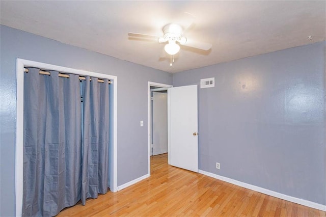 empty room with ceiling fan and light hardwood / wood-style floors