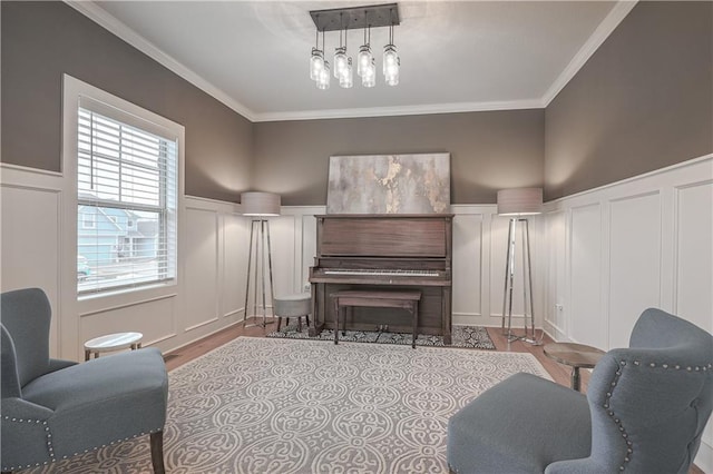 living area with crown molding and light hardwood / wood-style flooring