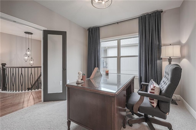 carpeted office with a notable chandelier