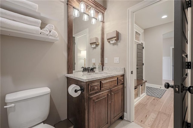 bathroom featuring vanity, wood-type flooring, and toilet