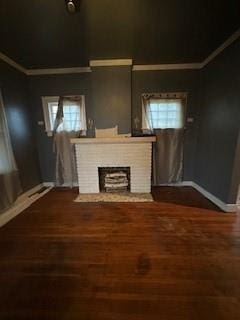 unfurnished living room featuring ornamental molding, hardwood / wood-style floors, a brick fireplace, and a wealth of natural light