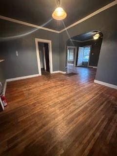 unfurnished living room featuring crown molding and dark hardwood / wood-style floors