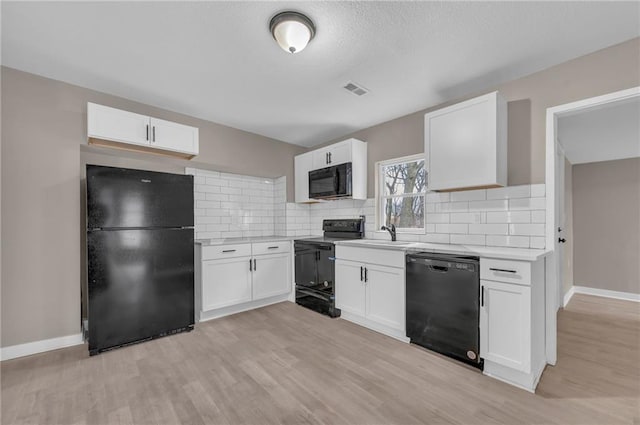 kitchen featuring black appliances, white cabinetry, light countertops, and backsplash