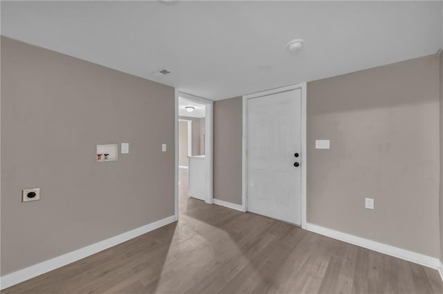 spare room featuring visible vents, baseboards, and wood finished floors