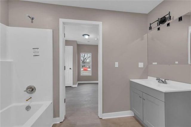 bathroom featuring  shower combination, vanity, baseboards, and wood finished floors