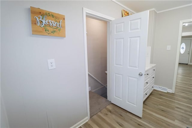 corridor featuring crown molding and light hardwood / wood-style floors