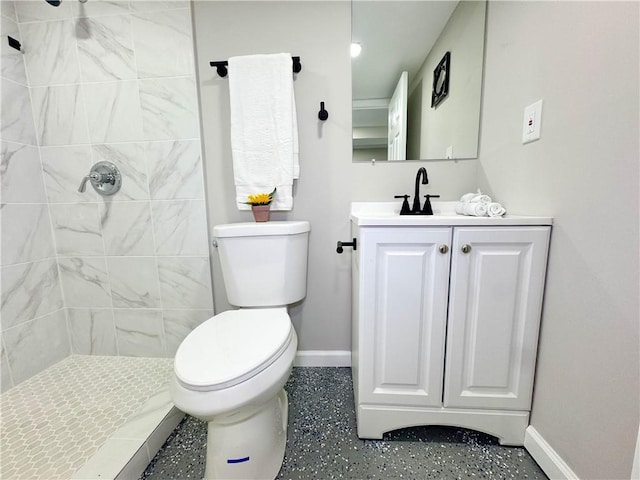 bathroom with vanity, toilet, and a tile shower