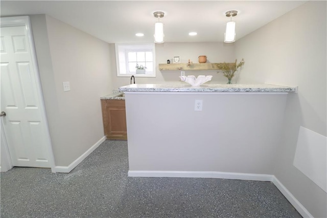 bar featuring light stone countertops, sink, and decorative light fixtures